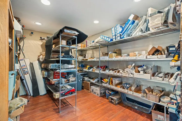 Interior space featuring wood-finish flooring, recessed lighting, and extensive built-in metal shelving