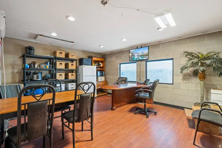 Spacious room featuring wood-finish flooring, block wall construction, and multiple windows for natural light