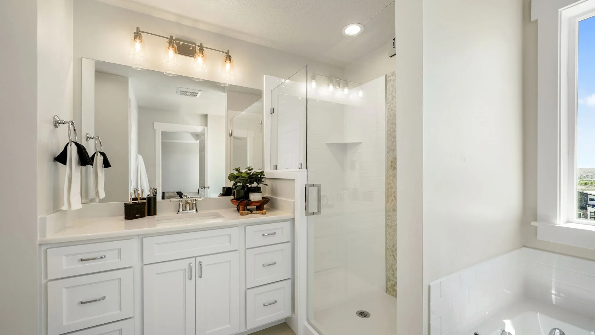 Spacious bathroom featuring a white vanity with an undermount sink and a large mirror