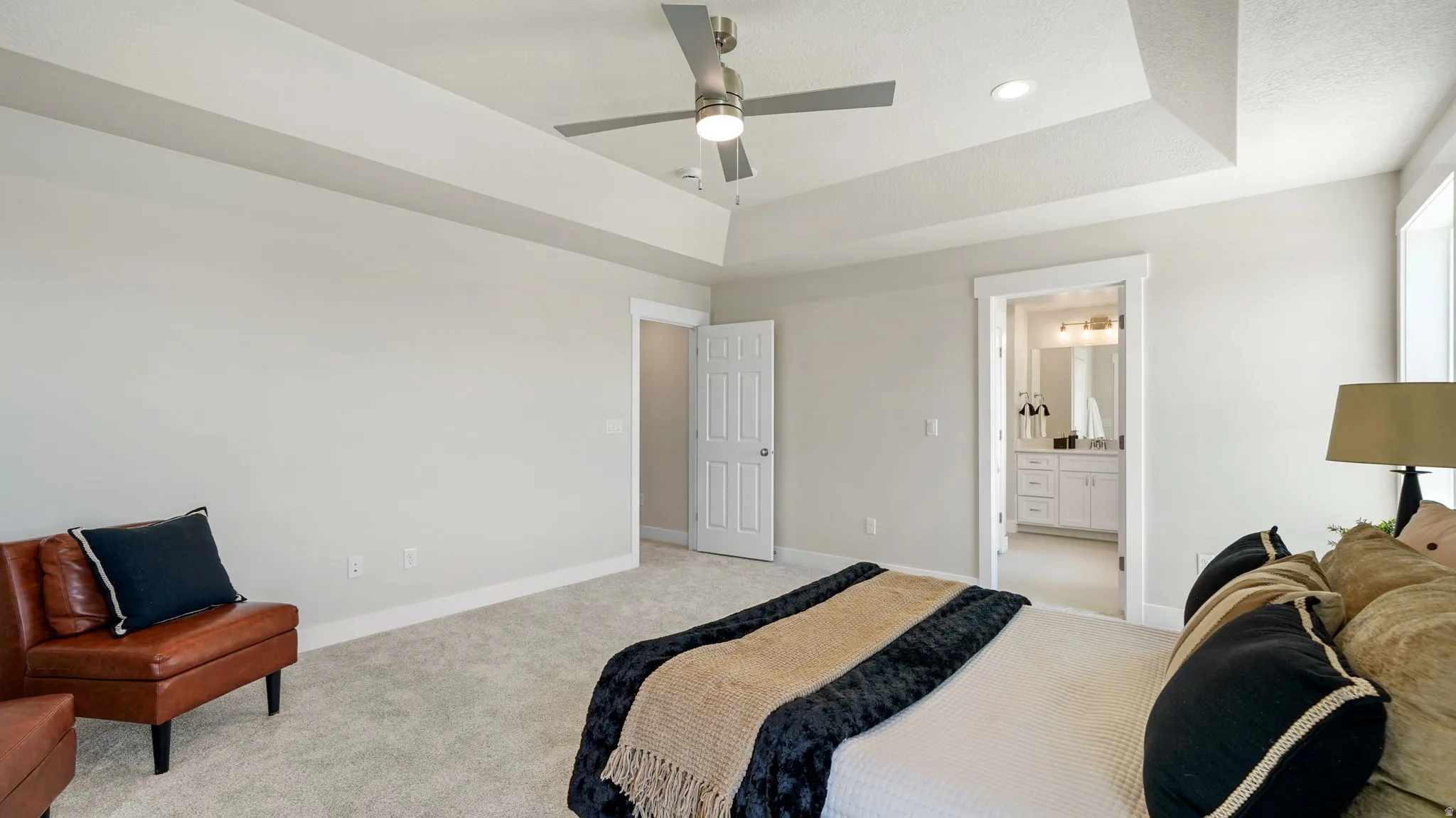 Spacious room featuring tray ceilings, recessed lighting, and light gray wall paint