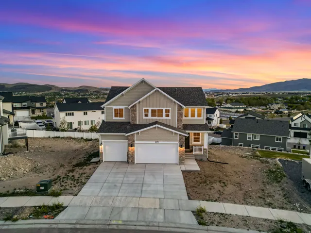 Contemporary two-story residence with a two-car garage, stone accents, and a covered entry porch