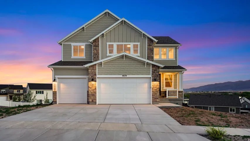 Two-story residence featuring a combination of horizontal siding, shake siding, and stone accents