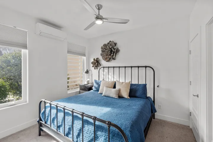 Bright room featuring high ceilings, a ceiling fan with integrated lighting, window blinds, and split-system air conditioning