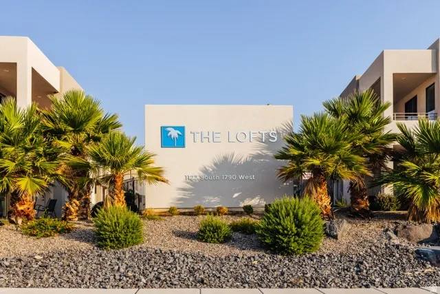 Contemporary architecture featuring a central sign for "THE LOFTS," flanked by mature palm trees