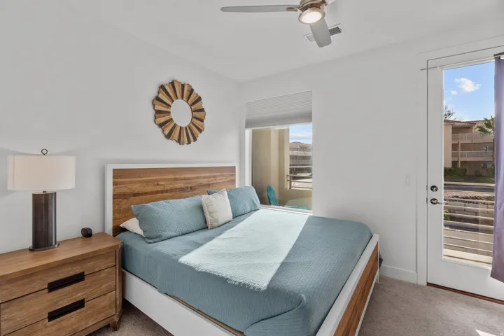 Bedroom featuring a wood-finish bed frame, white walls, and carpet flooring