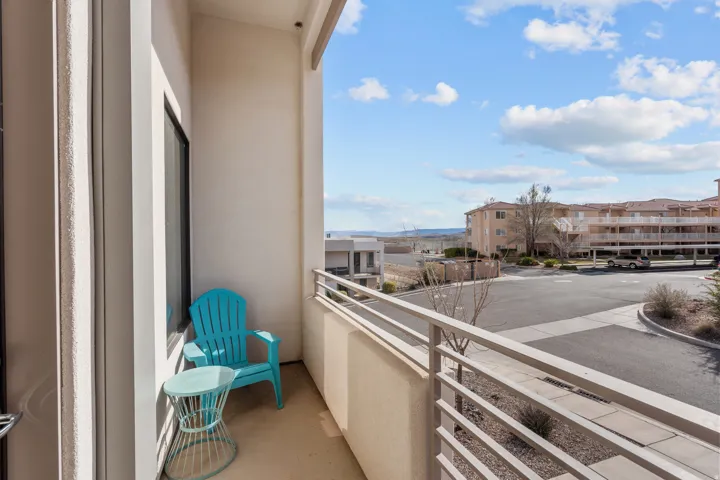 Private balcony featuring a light-colored railing, exterior wall, and concrete flooring