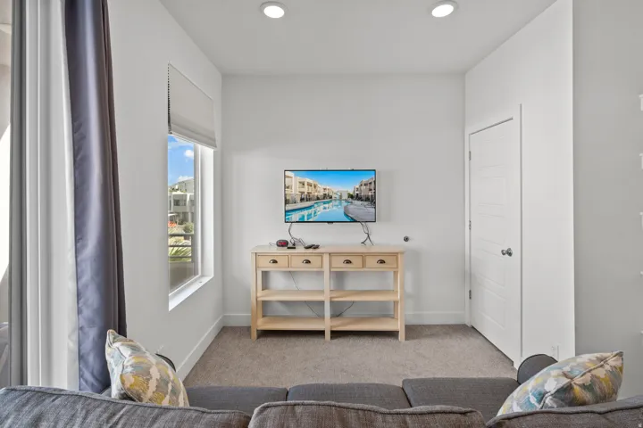 Recessed ceiling lighting illuminates a carpeted interior space with a window offering natural light