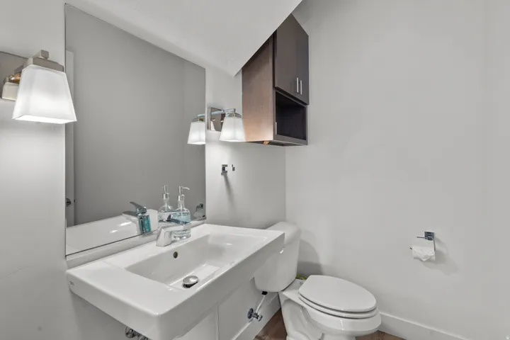 Modern vanity with a rectangular basin sink, chrome faucet, and expansive wall mirror