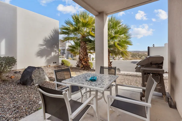 Covered patio featuring a concrete floor, stucco exterior walls, and a low-maintenance gravel landscape