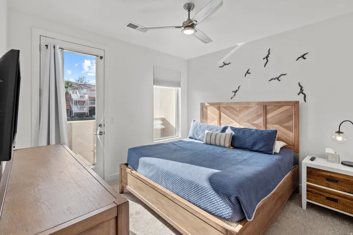 Bedroom featuring a private balcony, ceiling fan, and carpeted flooring