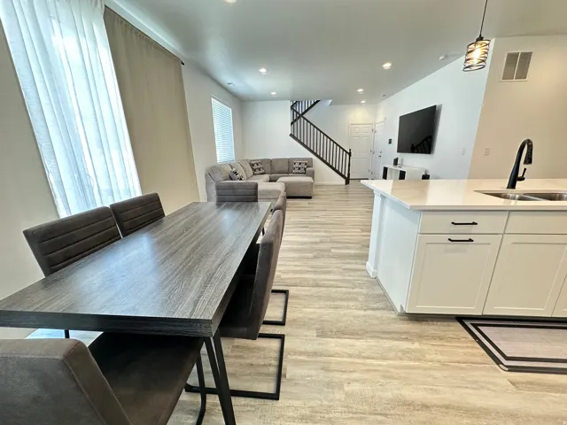Open-concept living space featuring wood-finish flooring, white walls, and recessed lighting