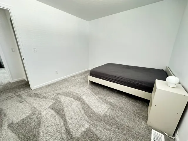 Room featuring plush gray carpet, white painted walls, and white trim molding