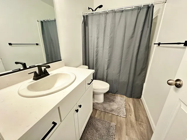 Bathroom vanity featuring a single basin sink and a white countertop