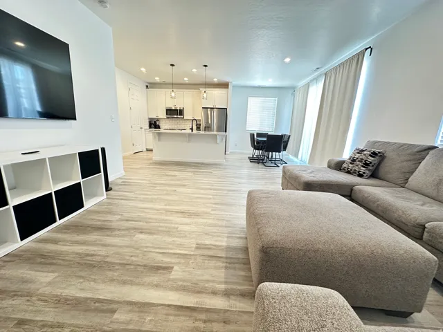 Open-concept living area with wood-finish flooring extending into the kitchen and dining areas