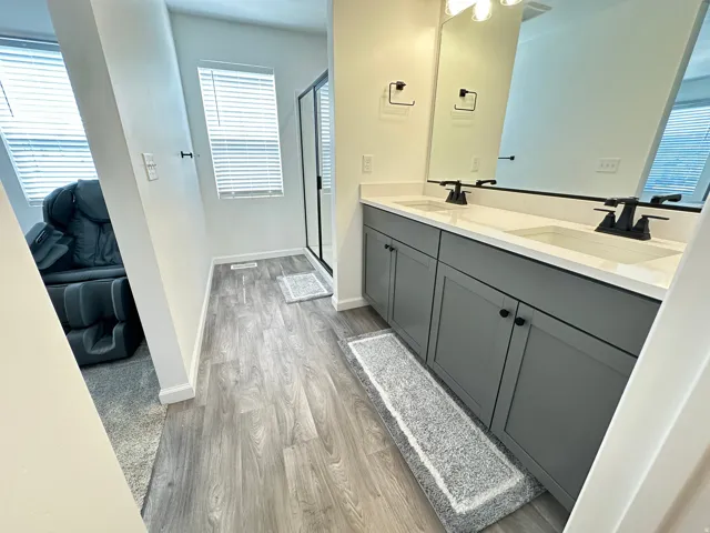 Double vanity featuring white countertops, dual sinks, and matte black fixtures