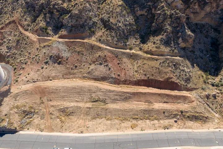 Terraced hillside building site featuring multiple graded pads and established road frontage