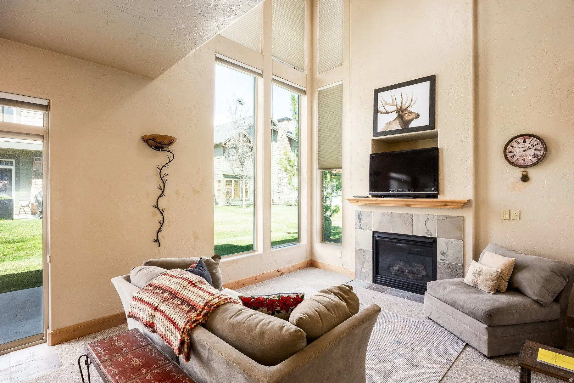 Living area featuring a floor-to-ceiling fireplace with a tile surround and wood mantel