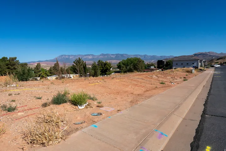 Expansive undeveloped lot featuring clear land, a paved sidewalk, and direct street access