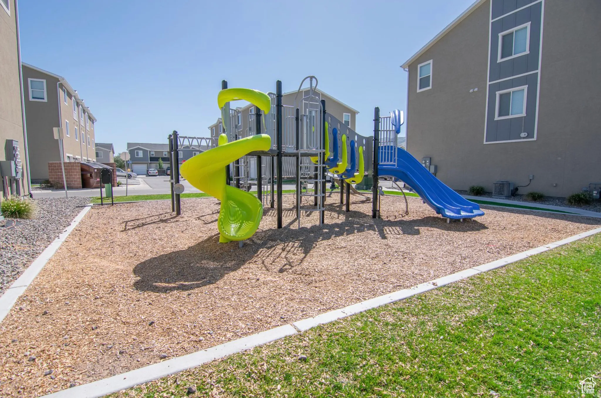 Outdoor play structure featuring a spiral slide and a straight slide