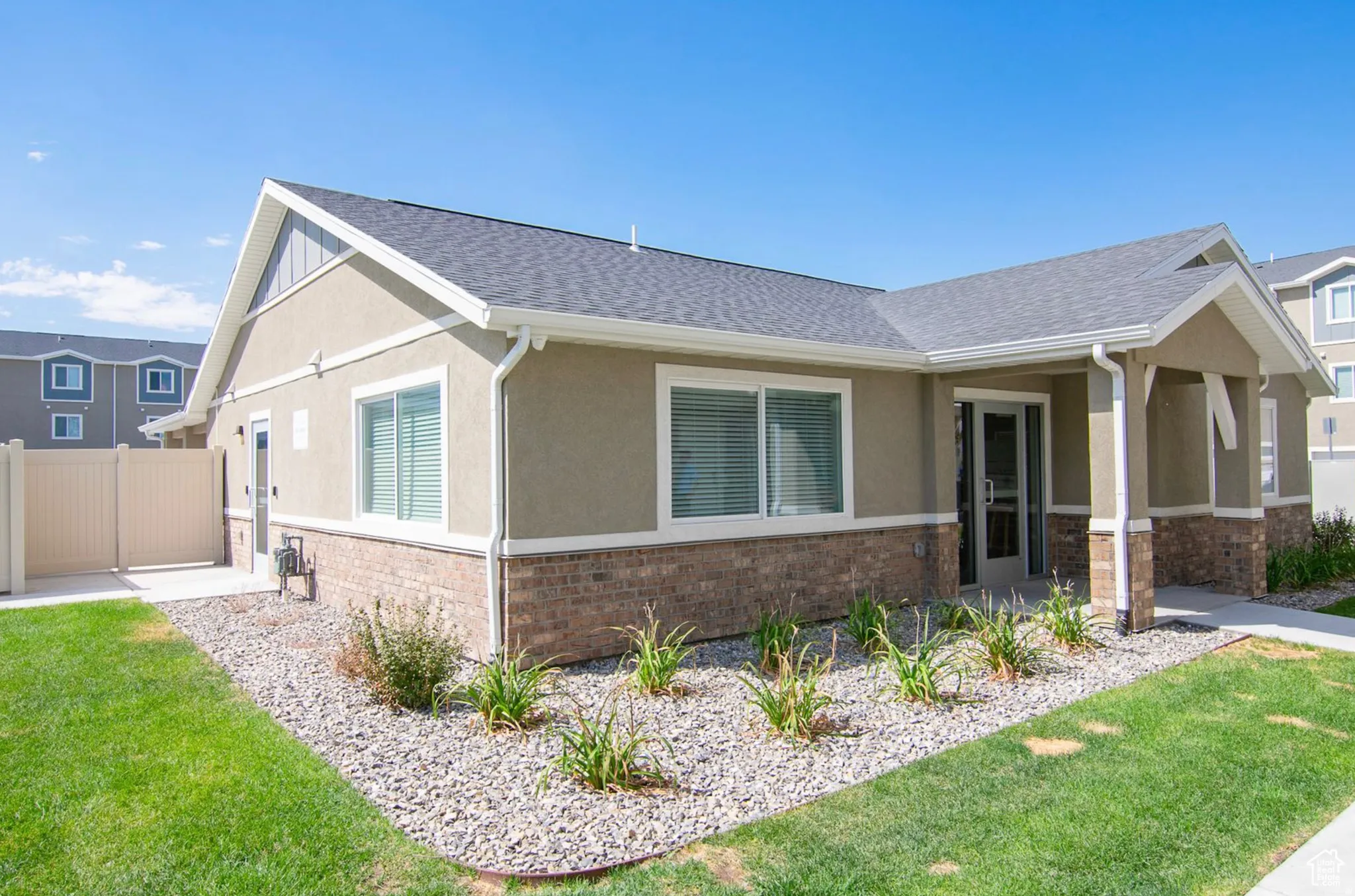 Single-story residence featuring a stucco exterior with brick accents and a covered entryway