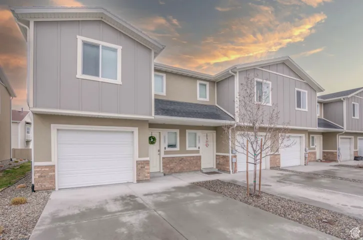 Contemporary exterior featuring a neutral stucco and board-and-batten facade with stone accents