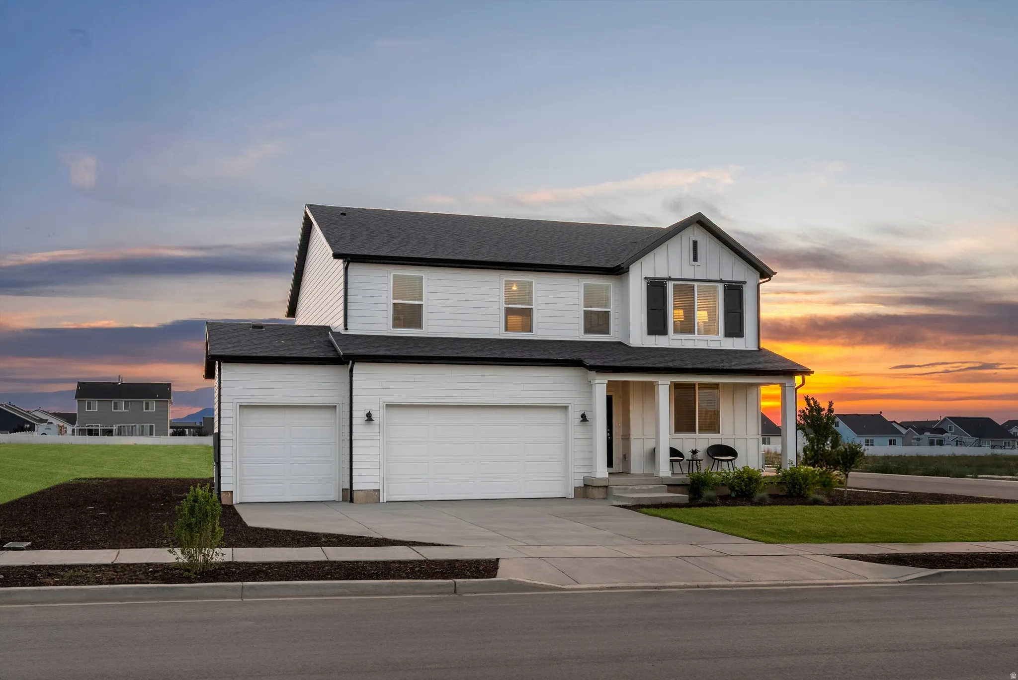Contemporary two-story residence featuring white siding and a contrasting black roofline