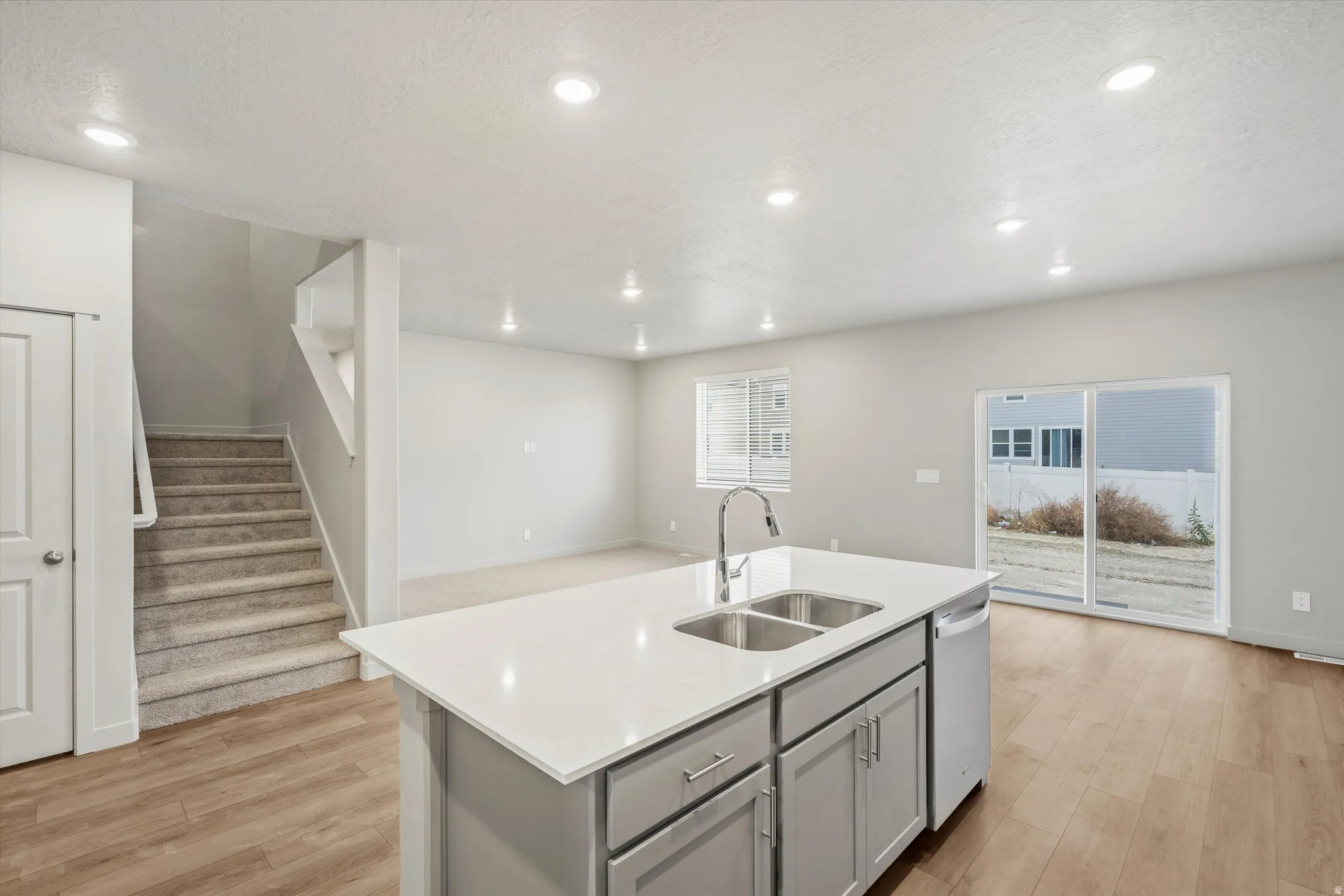 Kitchen island featuring a double-basin sink, chrome faucet, and integrated dishwasher