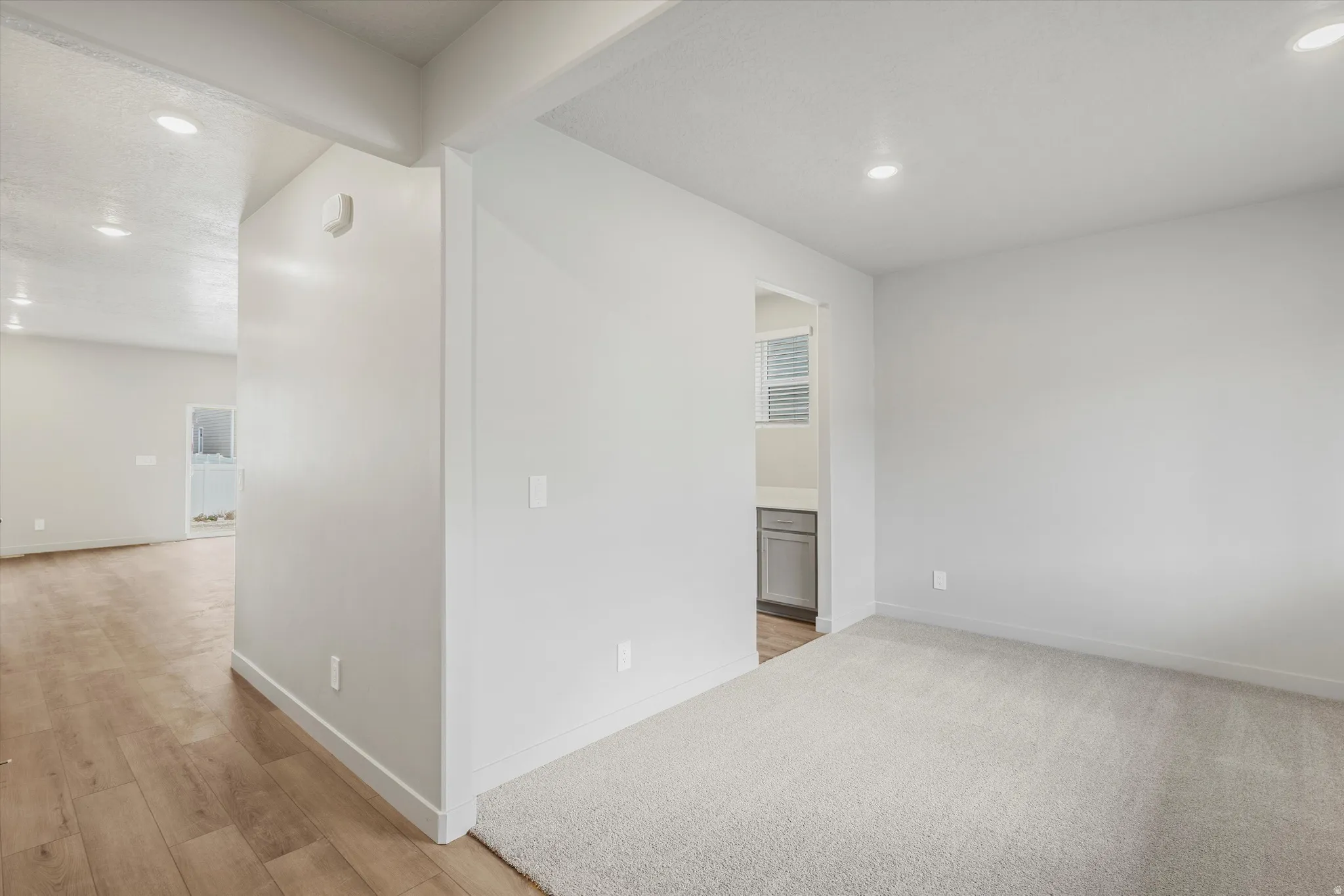 Open interior space featuring light-toned carpeting and recessed lighting