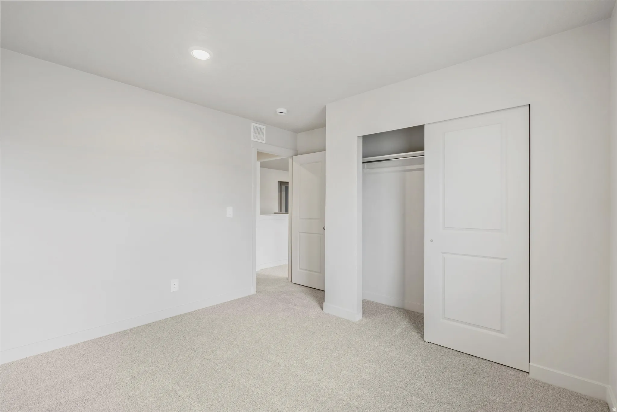 Light-colored carpeted flooring, neutral wall tones, and recessed lighting
