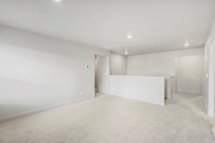 Open concept area featuring light gray walls, recessed lighting, white trim, and neutral-toned carpeting