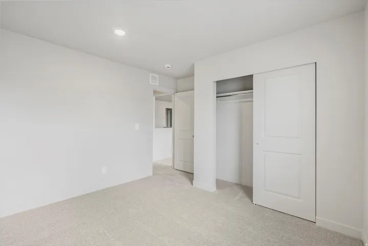 Light-colored carpeted flooring, neutral wall tones, and recessed lighting