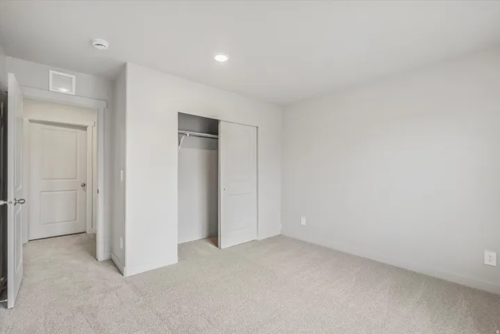 Neutral-toned room featuring light gray walls and plush carpeting