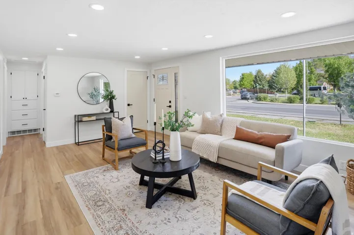 Open living space featuring wood-finish flooring, recessed lighting, and a large front-facing window