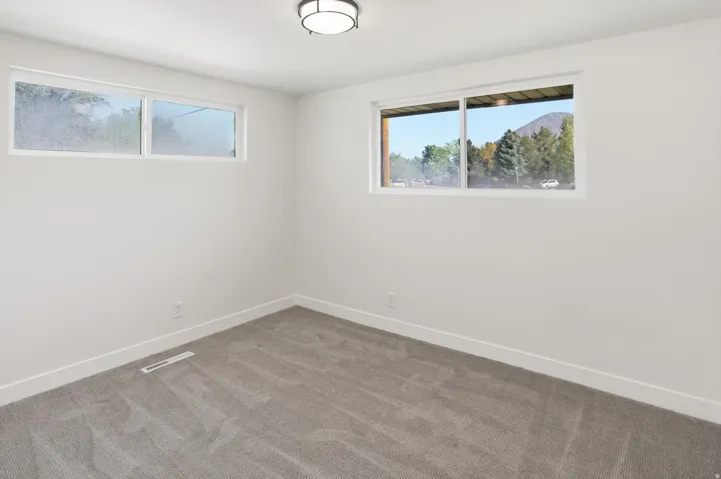 Bright room with white painted walls, gray carpet, and white trim