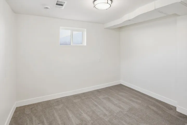 Neutral tone carpeting with white baseboards and walls