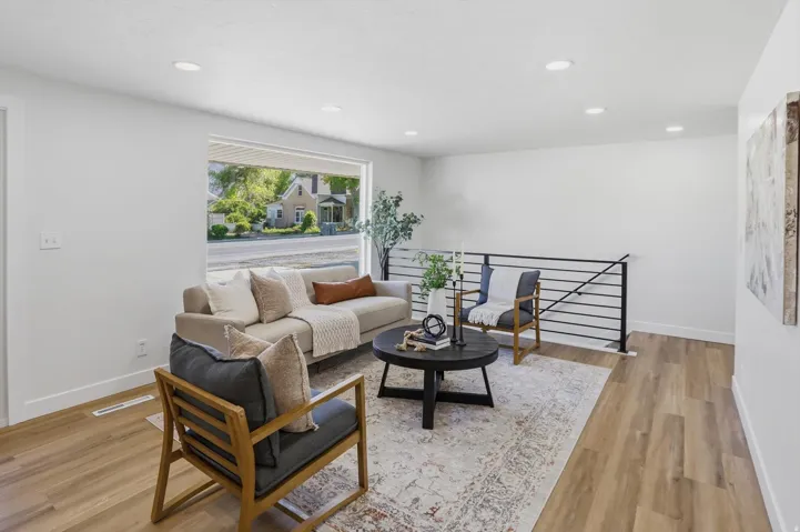 Open living area with light wood-finish flooring and recessed lighting
