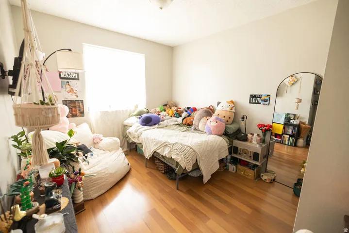 Spacious room featuring wood-finish flooring, light-toned walls, and a large window