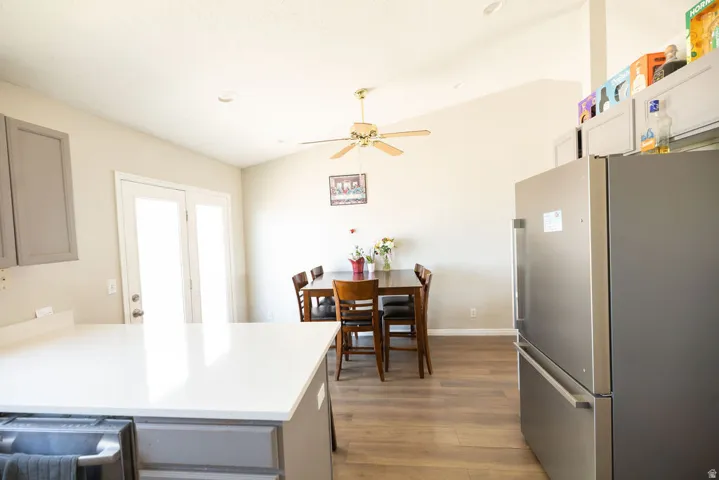 Bright kitchen area with white countertops, wood-finish flooring, and light gray cabinetry