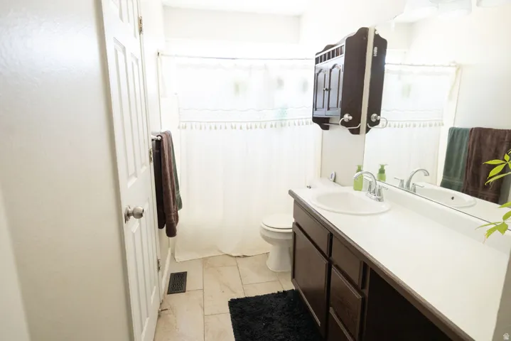 Vanity with integrated sink and chrome faucet, set against a full-width wall mirror