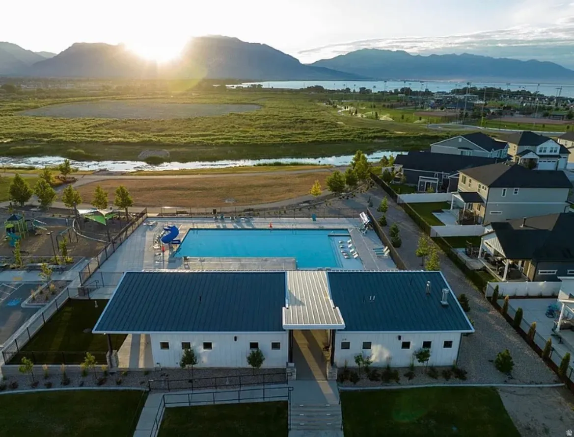 Community recreational building featuring a swimming pool, adjacent playground, and surrounding residential properties
