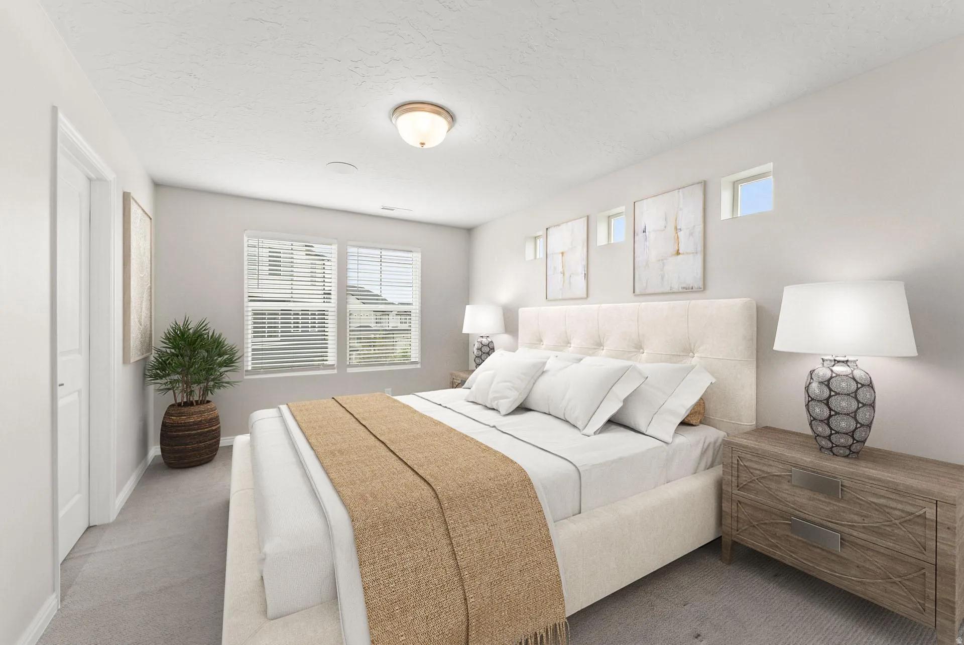 Spacious bedroom featuring light gray carpeting, neutral wall colors, dual windows with blinds, a built-in overhead light fixture, and high transom windows
