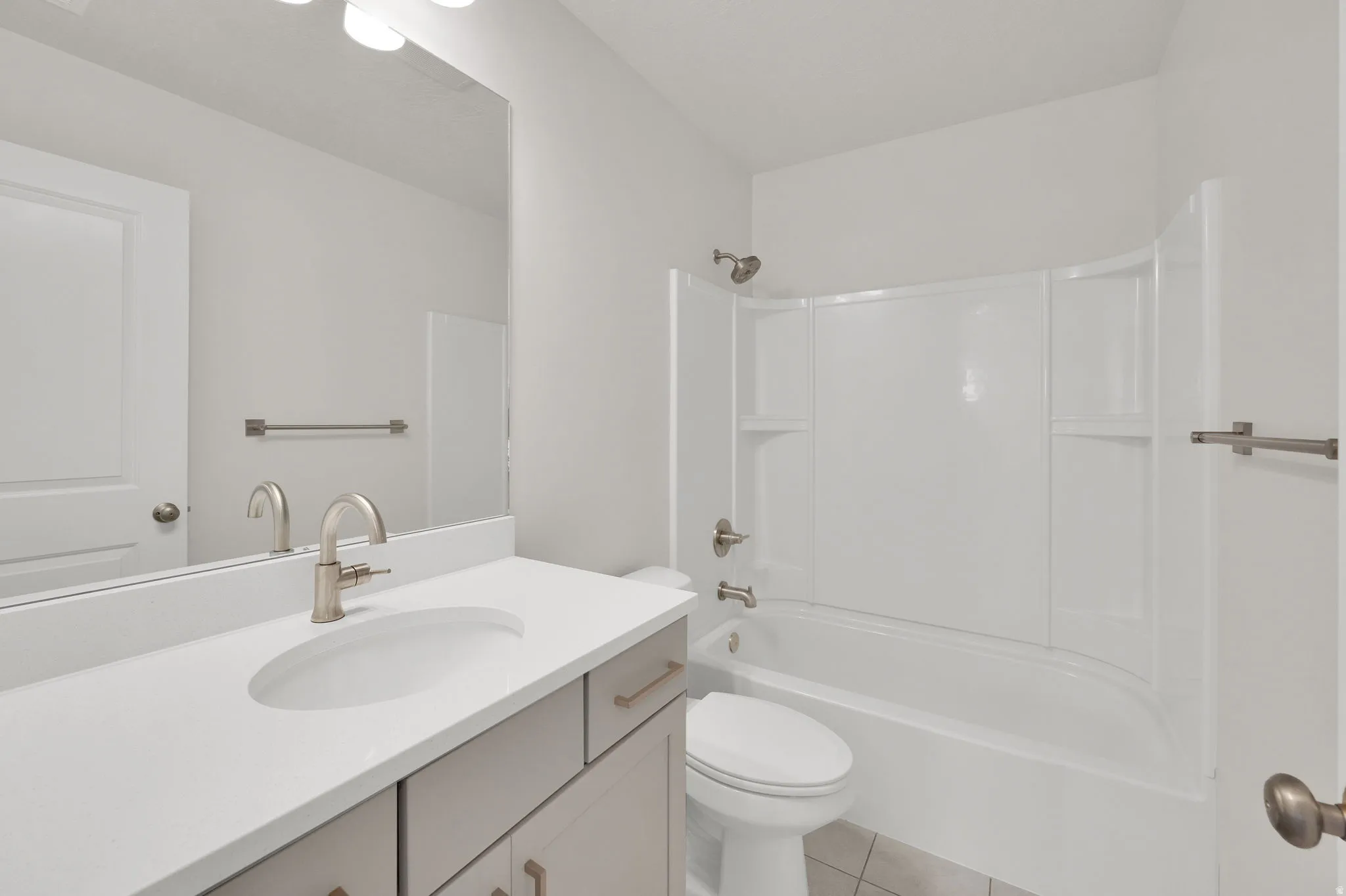 Bathroom featuring a single vanity with an integrated sink, brushed nickel faucet, and a large wall-mounted mirror