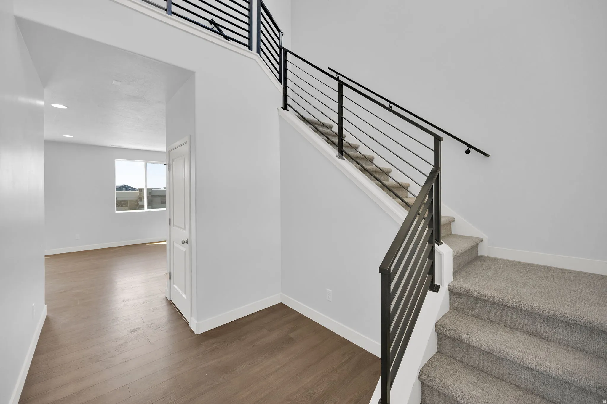 Open-concept entry with modern horizontal metal railing staircase