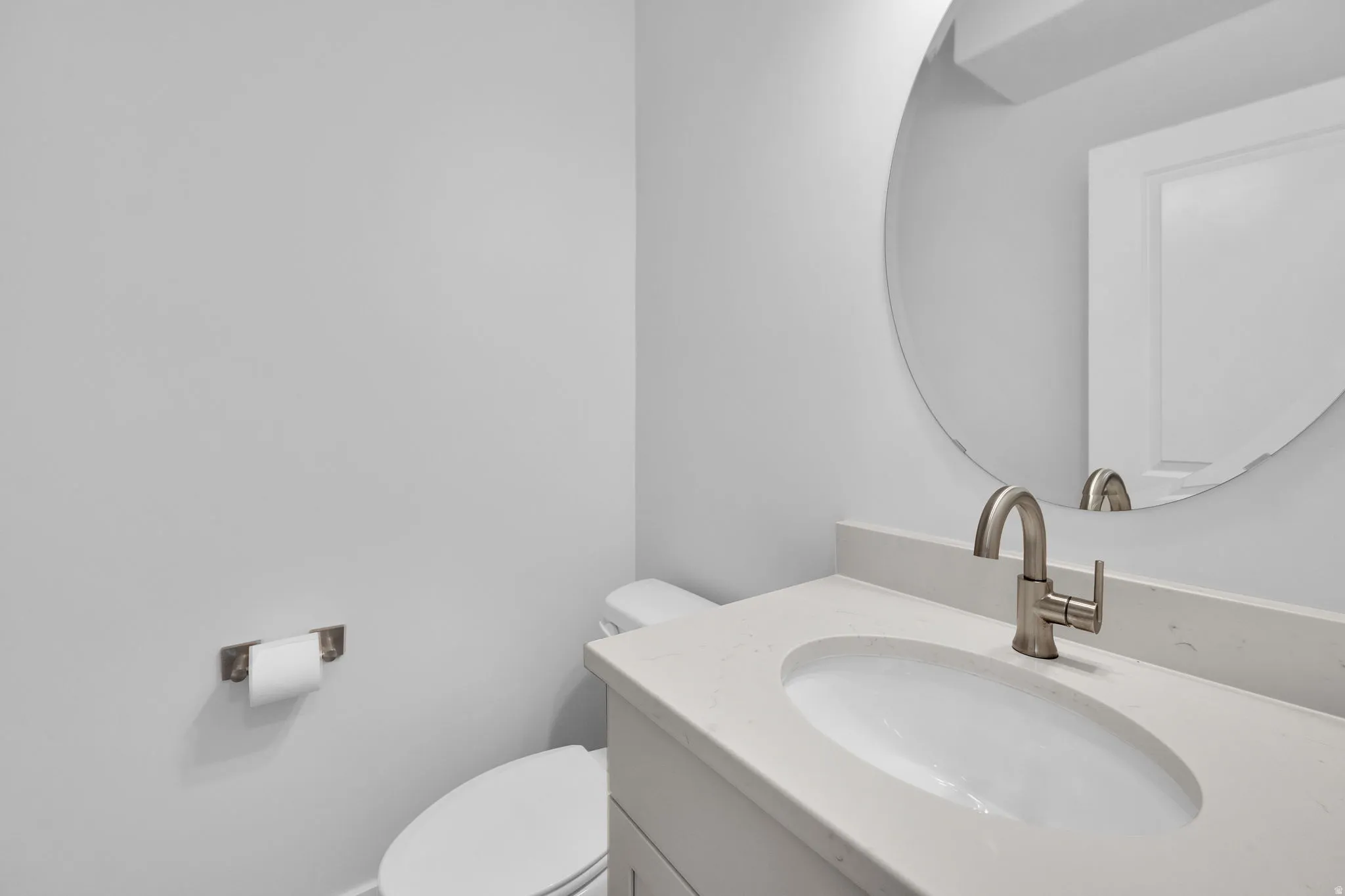 Vanity featuring a single undermount sink, a light-toned countertop, and a brushed nickel faucet