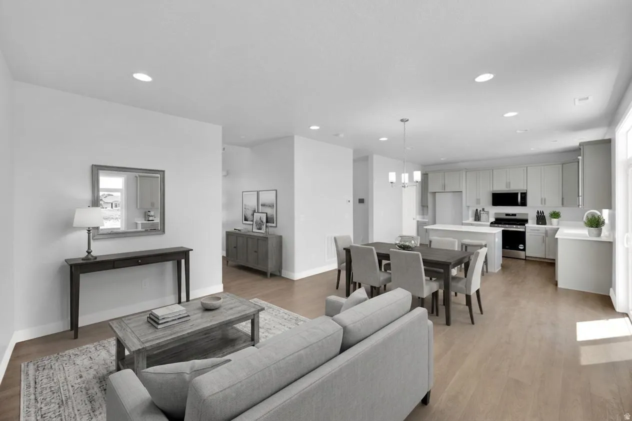 Open concept living space featuring wood-finish flooring, recessed lighting, and a modern kitchen with a center island