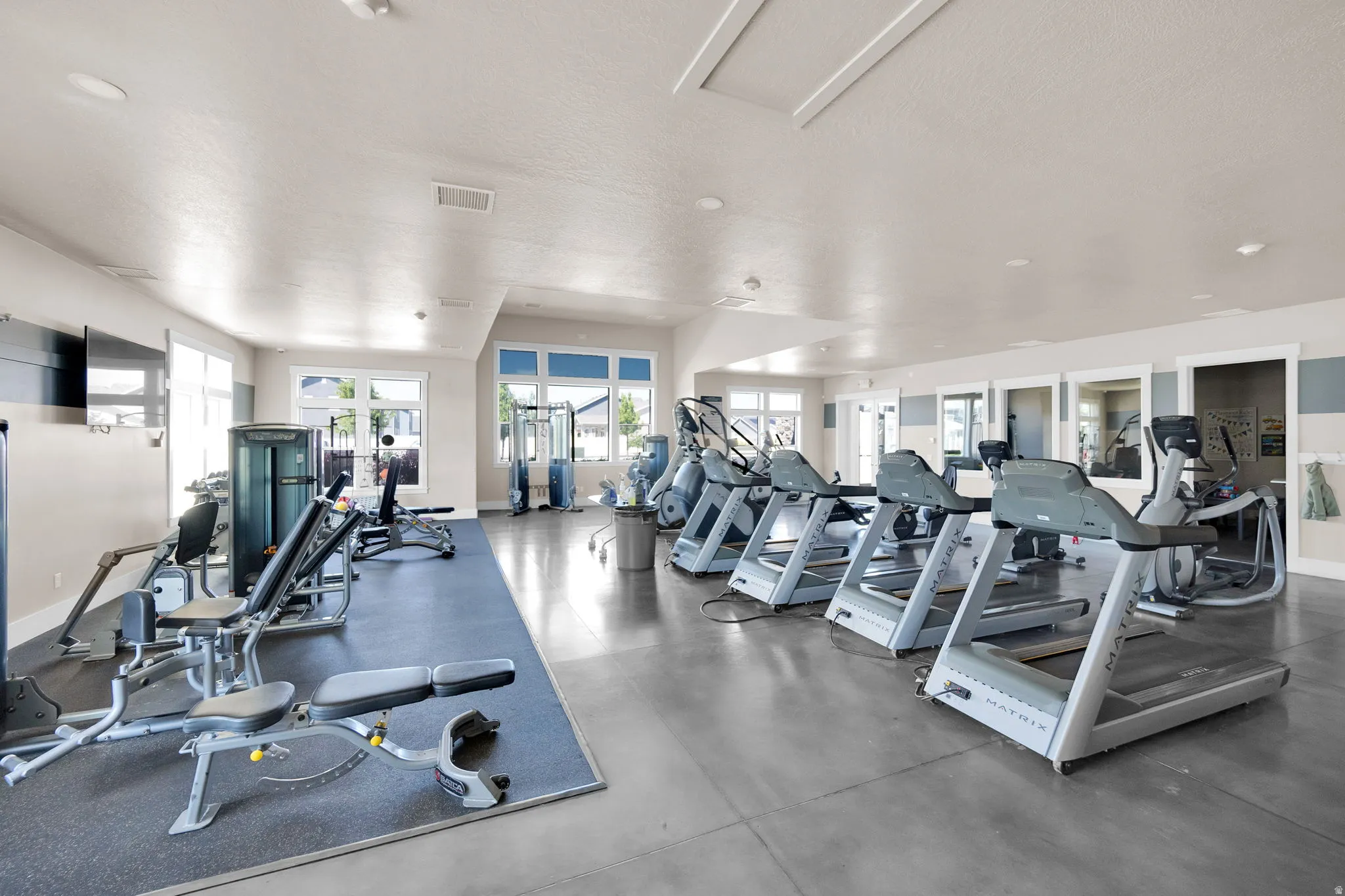Community fitness center featuring multiple treadmills and weight training equipment