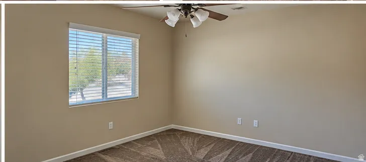 Room featuring neutral-toned walls, patterned carpet, a single window with blinds, and a ceiling fan with integrated lighting