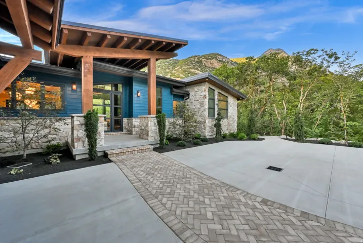 Modern residence featuring an expansive concrete driveway and a herringbone paver walkway