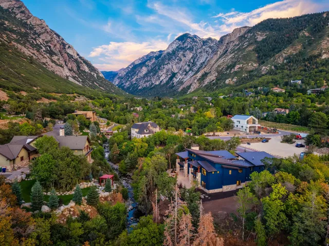 Modern architecture with blue siding and stone accents nestled in a mountainous landscape