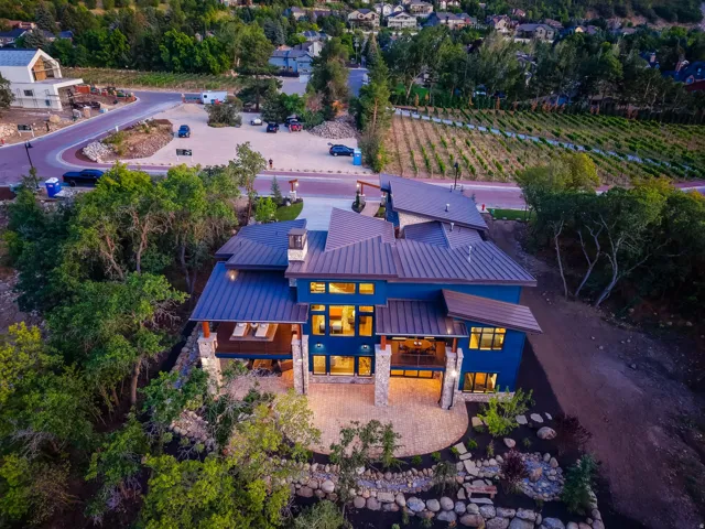 Contemporary residence featuring a blue exterior, multiple large windows, and a multi-level roofline